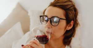 Woman drinking wine in bed