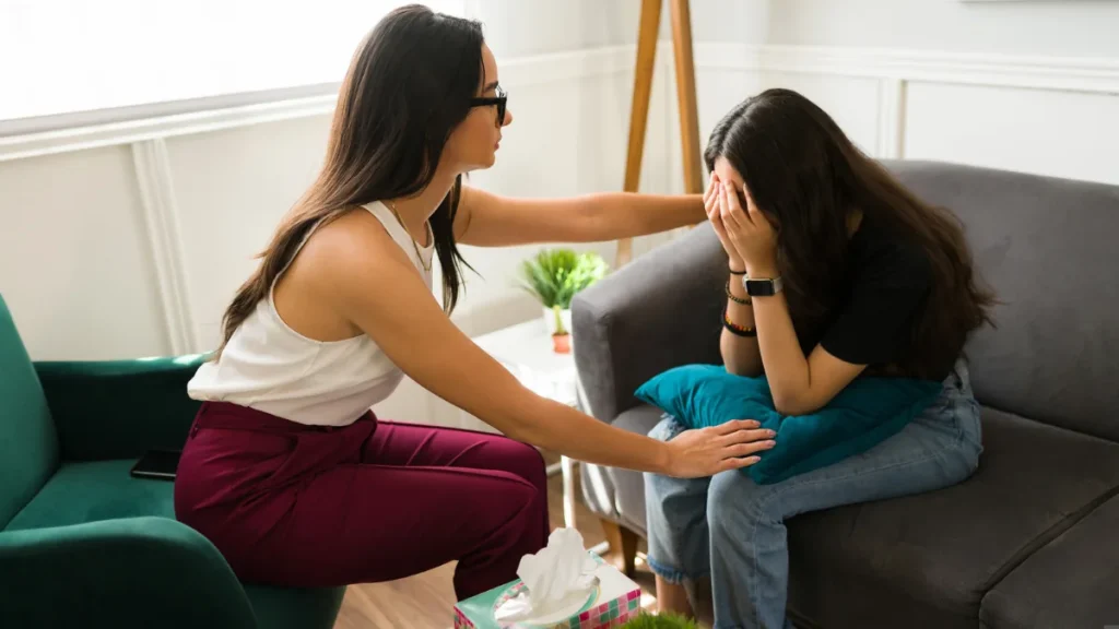 Therapist comforting a distressed young woman during a counseling session
